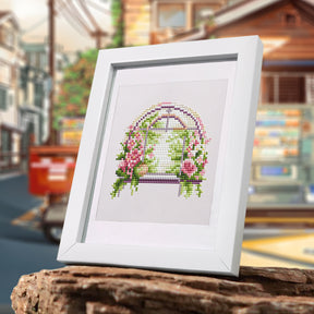 Framed FloraleFenster Diamond Painting Set with Mini Kunst design displayed on a wooden surface.