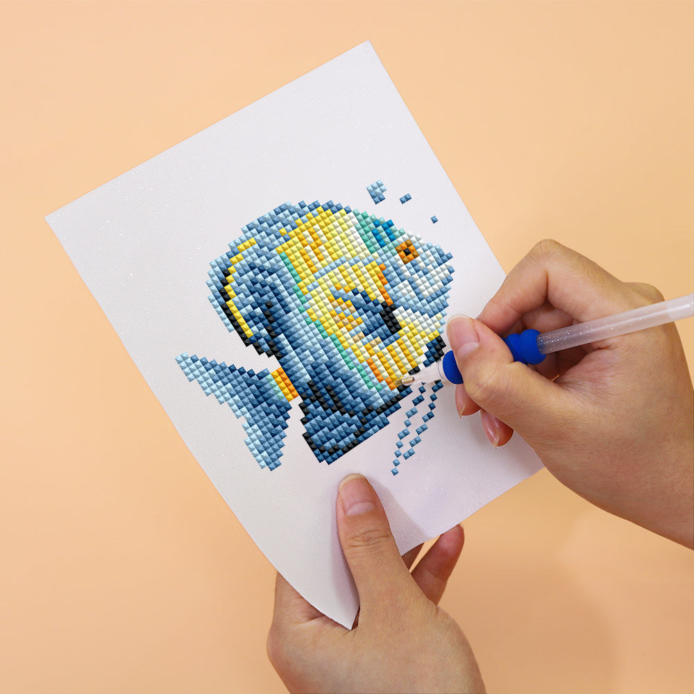 Hand creating a colorful fish diamond painting from Meeresbewohner 12er SET, showcasing detailed miniature Kunst (art).