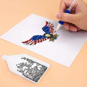 Hand completing USA-themed diamond painting mini art of an eagle using a diamond painting pen.