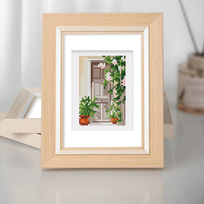 Framed diamond painting featuring a scenic view with greenery and potted plants, perfect for mini kunst and home decor.