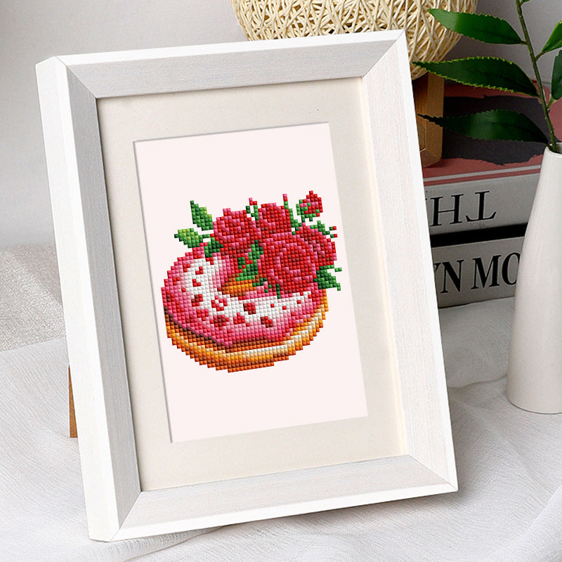 Framed mini art of a diamond painting featuring a pink cake with red roses, designed for the Love Edition 12er SET.